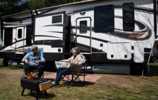 Couple in front of fifth wheel rv skirting