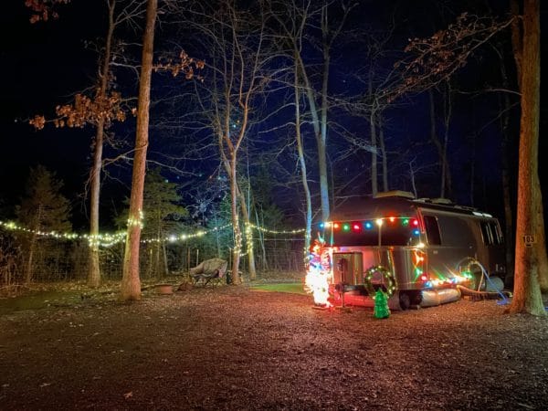 rv skirt photo of airstream in woods at night with colored lights